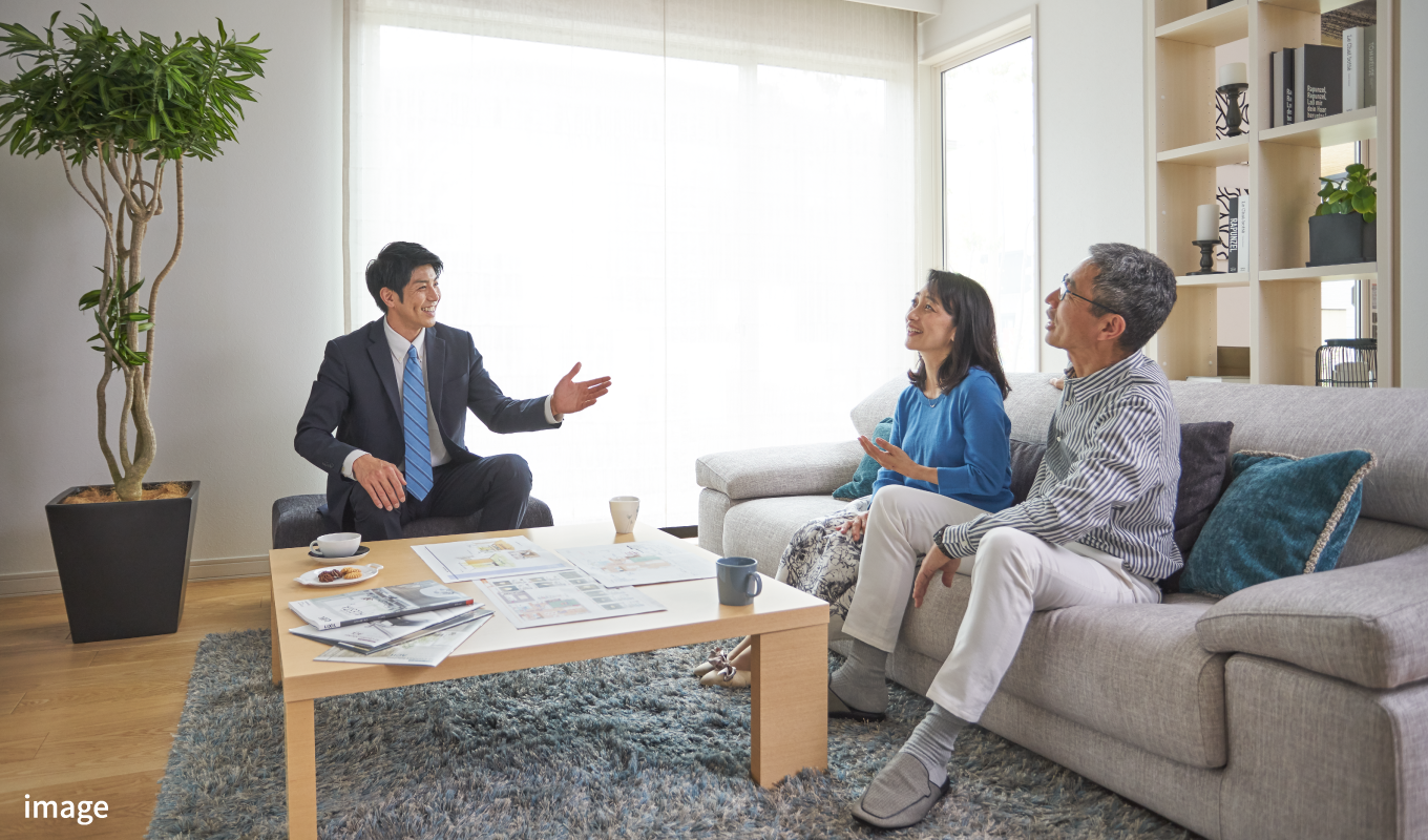 リビングで住宅の相談をする夫婦と社員の写真