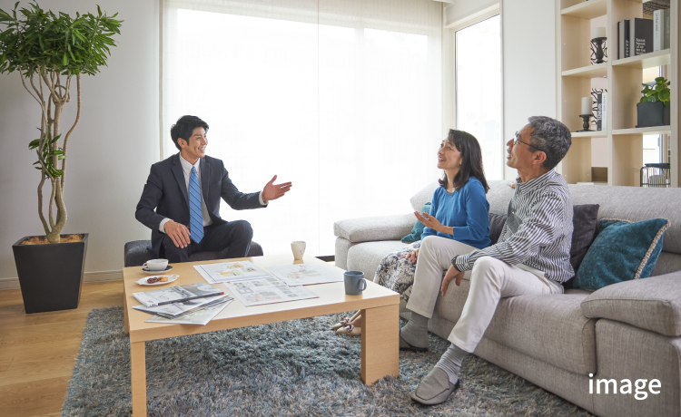リビングで住宅の相談をする夫婦と社員の写真