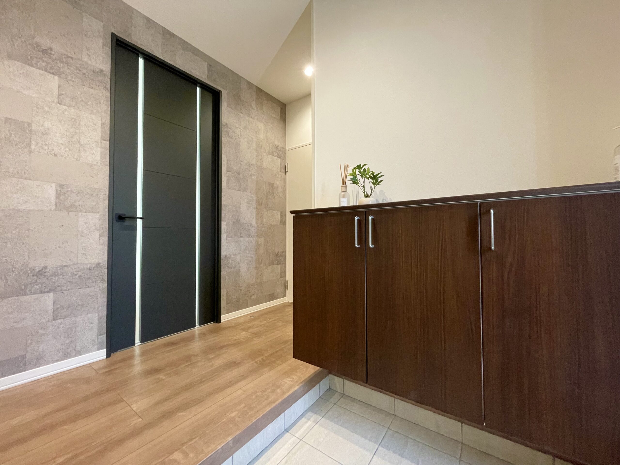 玄関はタイル調の壁紙で落ち着いた雰囲気を演出！