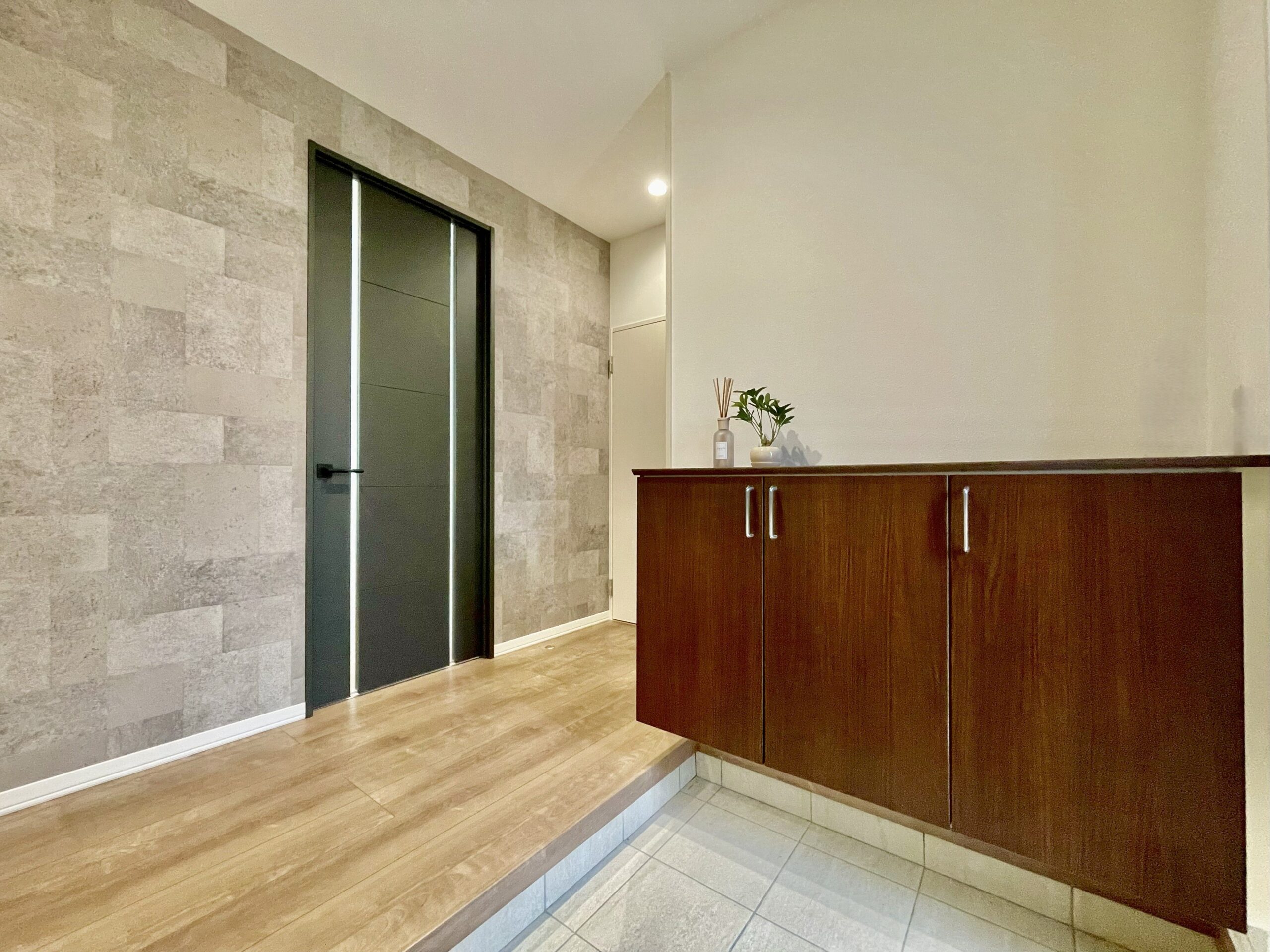 玄関はタイル調の壁紙で落ち着いた雰囲気を演出！