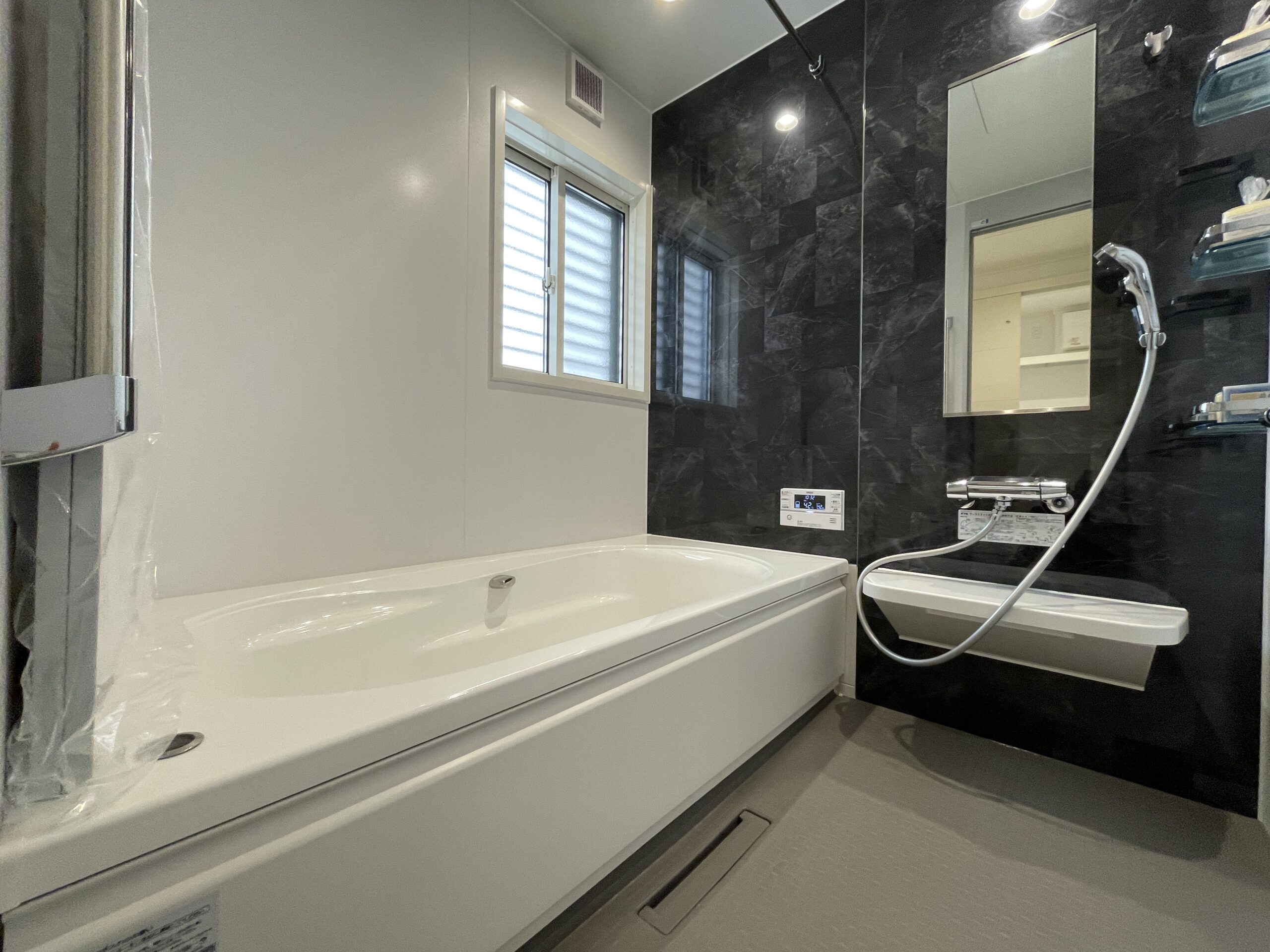 ダークカラーがアクセントとなっているモダンな浴室空間。